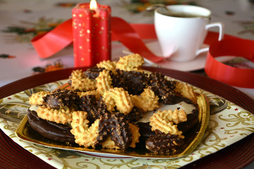 Christmas cookies decorated with chocolate on a plate and cup of coffee