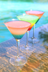 Cocktails on swimming pool background