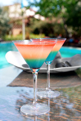 Cocktails on swimming pool background