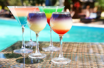 Cocktails on swimming pool background
