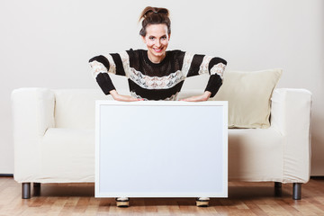 woman on sofa holding blank presentation board.