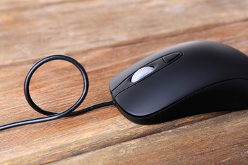 Computer mouse with cord on wooden background
