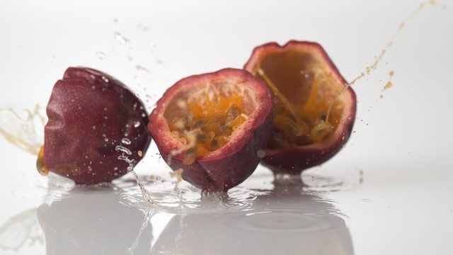 Passion fruit falling and bouncing on water surface. Shot with high speed camera, phantom flex 4K.  Slow Motion. 