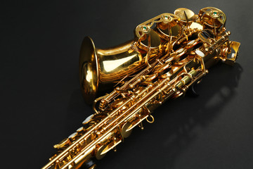 Obraz na płótnie Canvas Beautiful golden saxophone on black background, close up