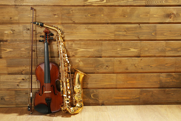 Violin and saxophone on wooden background