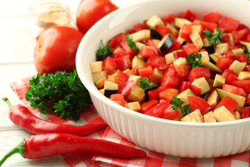 Ratatouille before cooking and ingredients, on wooden background