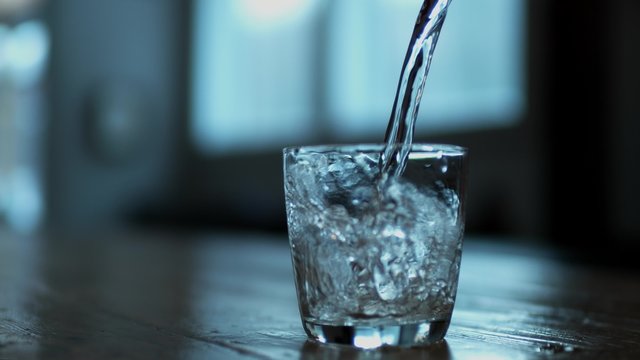 Pouring water into glass. Shot with high speed camera, phantom flex 4K. Slow Motion. 