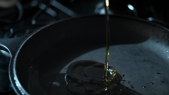 Pouring oil over fry pan. Shot with high speed camera, phantom flex 4K. Slow Motion.
