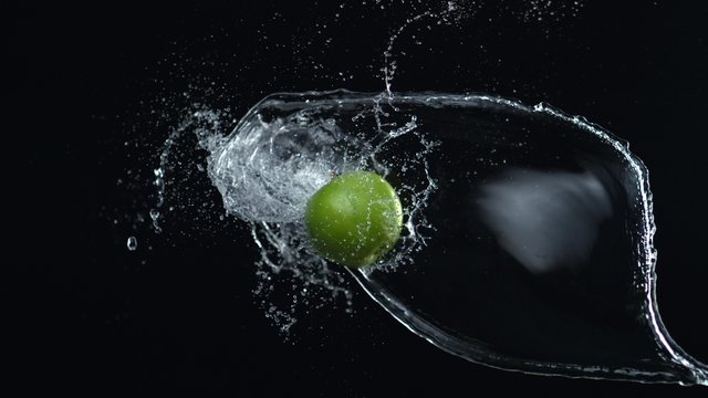 Apple colliding against water splash. Shot with high speed camera, phantom flex 4K. Slow Motion.