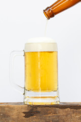 Pouring beer into glass on white background.