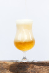 Pouring beer into glass on white background.