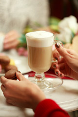 Woman holding cup of latte in cafe
