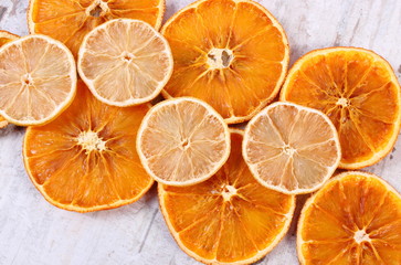Slices of dried lemon and orange on old wooden background