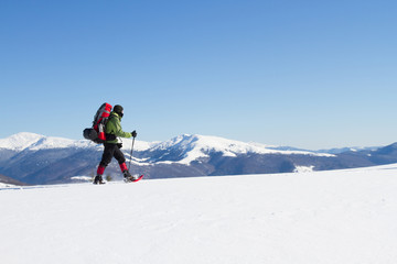 Fototapeta na wymiar Hiker in winter mountains snowshoeing.