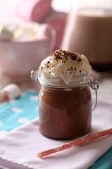 Glass jar of chocolate milk on table close-up