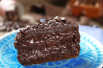 Chocolate cake with chocolate cream and fresh blueberries on plate, on wooden background