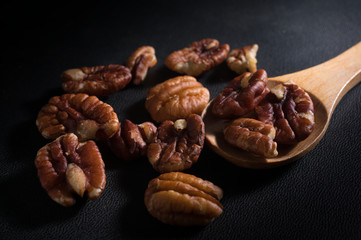 Pecan nuts with wooden spoon.