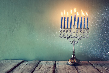 abstract retro filtered low key image of jewish holiday Hanukkah with menorah (traditional...