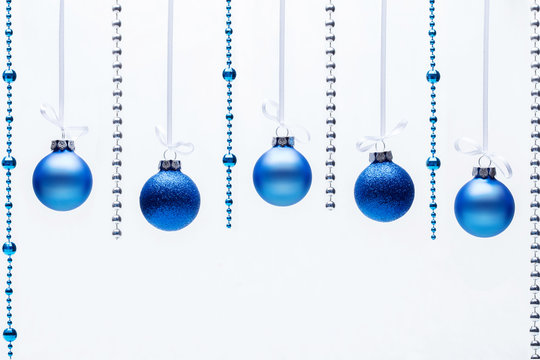 Blue Christmas balls with beads on white background. Copyspace for your greeting or wishes