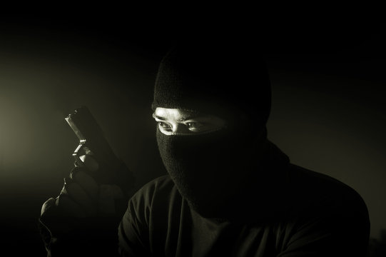 Robber man hold gun,monochrome filtered.