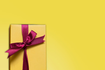 yellow love gift box and pink ribbon with yellow background