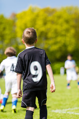 Young boy watching a kids soccer match
