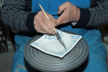 Mani al lavoro, dipingendo la ceramica 