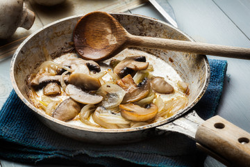 Sliced mushrooms with onion on a pan