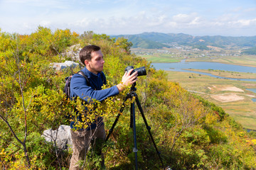 Photographer on the camera shoots landscape