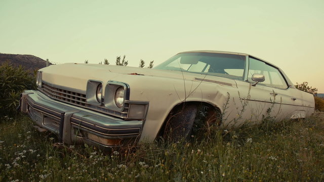 Old abandoned american vintage car in a field