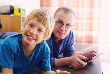 father and son playing games on tablets