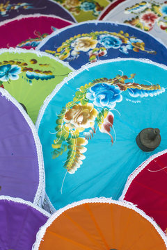 trading in traditional Asian silk umbrellas in the craft village in the Thai province of Chiang Mai