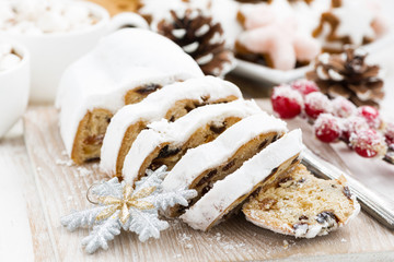 Christmas Stollen on a wooden board and cookies, closeup