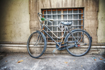 Fototapeta na wymiar old bicycle against a rustic wall in Florence