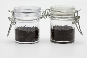 Ecology concept (two little glass jar with soil)