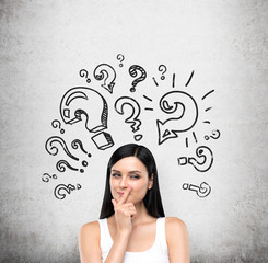 A portrait of a young artful brunette lady who is trying to find out a solution of some problem....