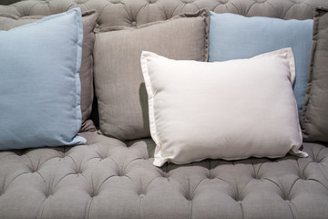 white grey blue pillows on grey sofa