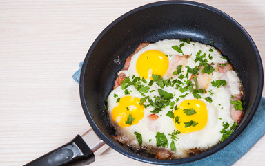 fried eggs with bacon in a frying pan