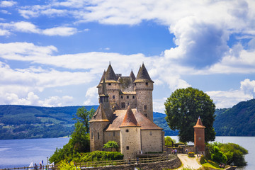 Fototapeta premium Cinematic View of Chateau de Val Castle on Lake. Fairy Tale Fortress in Auvergne. Historic French Landmark Lanobre France. High Resolution World Print.
