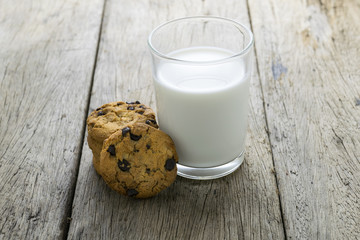 cookies and a glass with milk on wooden table
