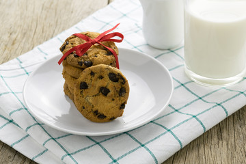 cookies and a glass with milk on wooden table
