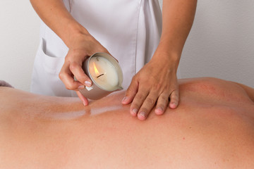 Woman receiving shoulder candle massage at Spa center