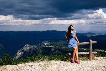 Naklejka premium woman relax on peak of mountain with rainy sky
