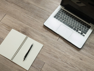 Laptop computer and a black pencil on a notebook