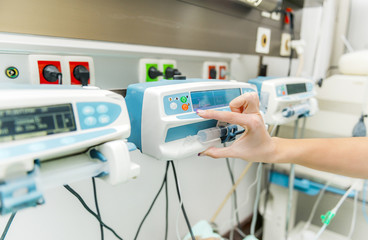 Intensive care inffusion pump adjusted by a nurse hand