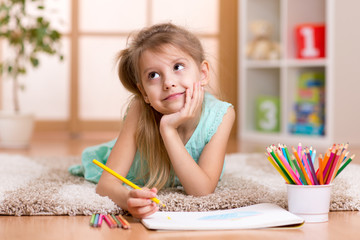 dreamy child girl drawing with color pencils