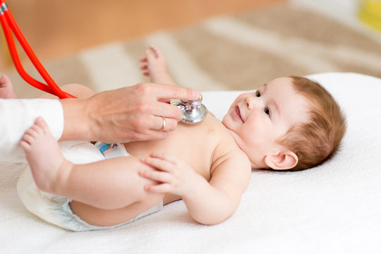 Pediatrician examines three months baby boy. Doctor using a stethoscope to listen to kid's chest checking heartbeat