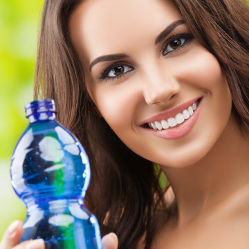 Young woman showing bottle of water