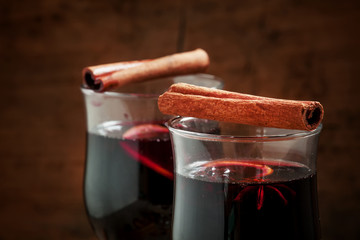 Hot mulled wine with spices on an old wooden background, selecti