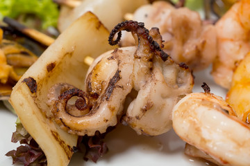 Grilled seafood platter with hot sauce.